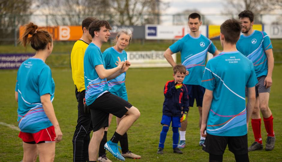 De voetbalploeg van Familiehulp overlegt voor de match.